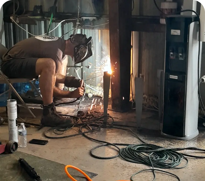 Worker welding steel inside facility mechanical room