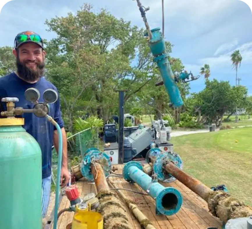 Roughneck Ranch technician beside pump house piping and well equipment