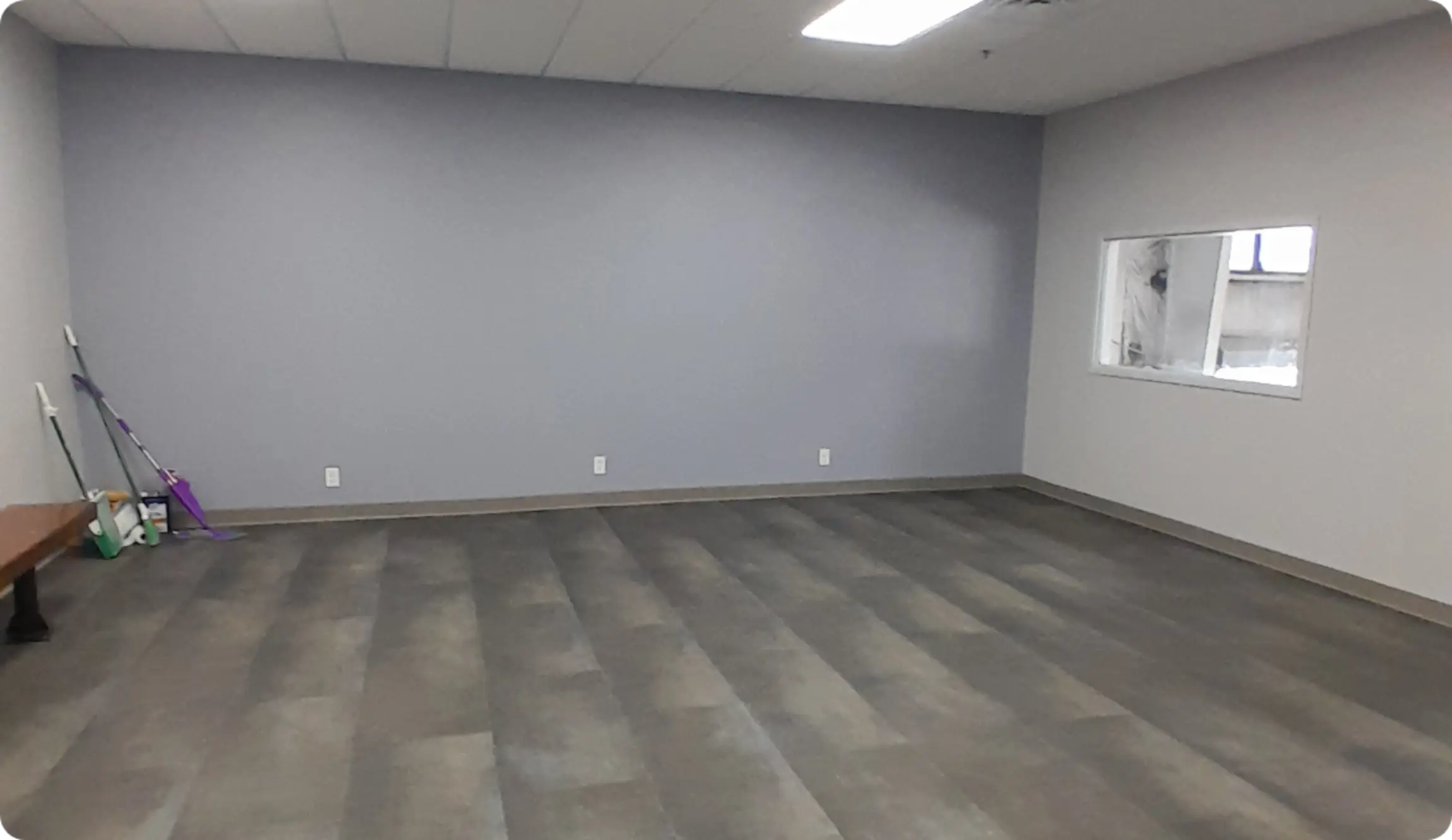 Empty renovated office room with gray walls and vinyl flooring