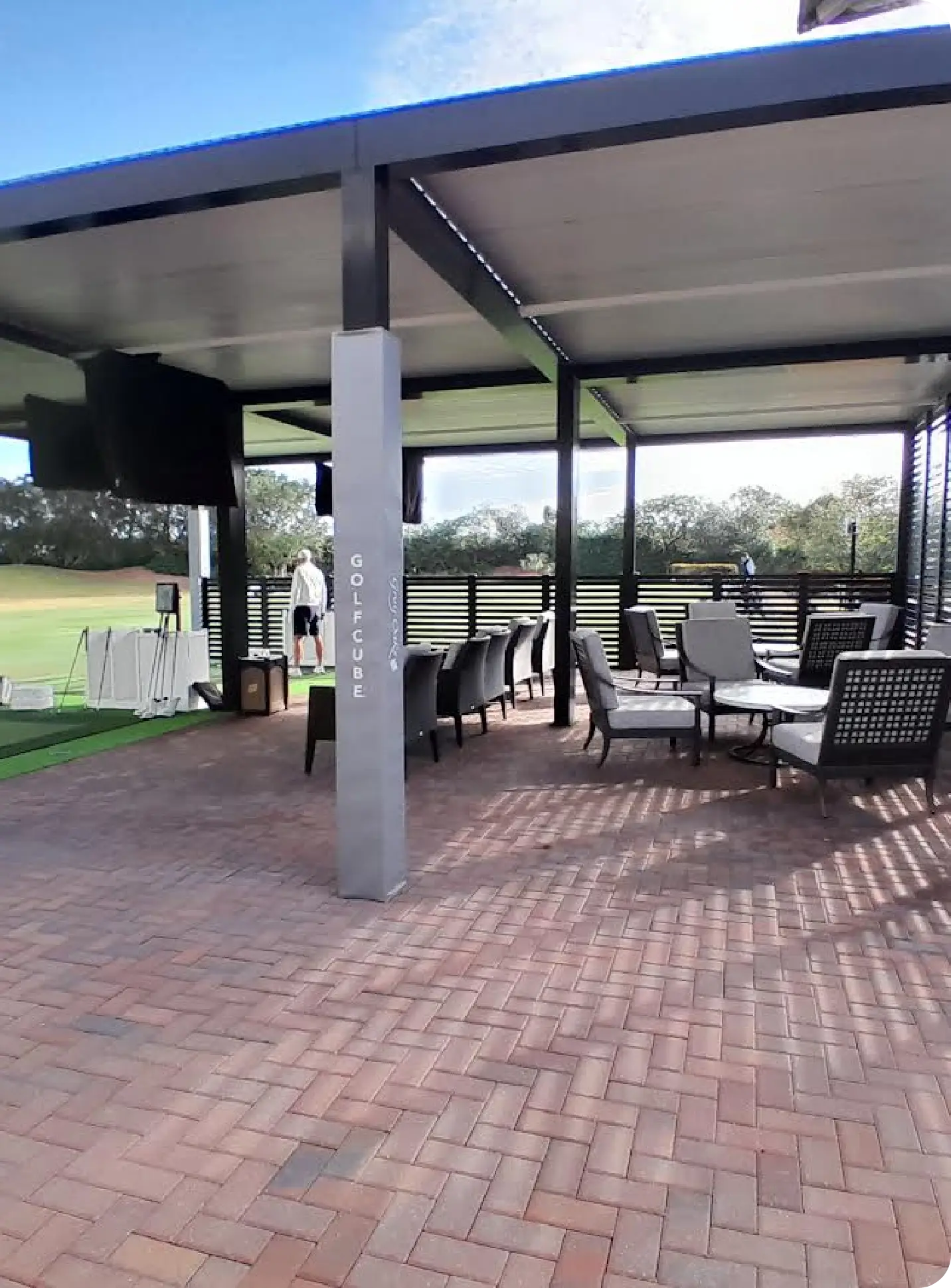 Covered Golf Cube patio with lounge seating overlooking the range