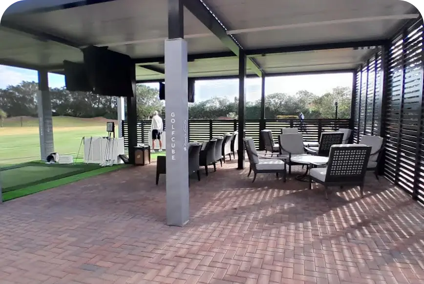Covered brick patio lounge overlooking turf at performance center