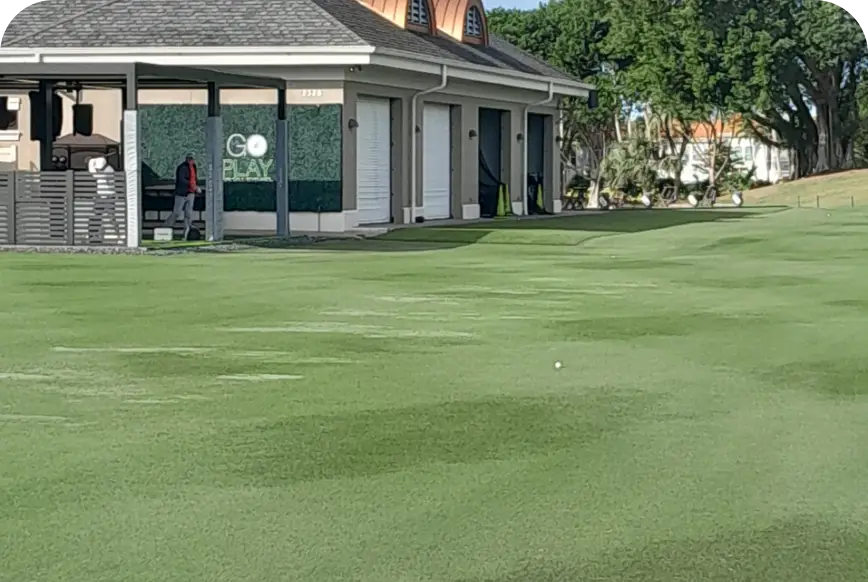 Manicured putting green fronting golf course performance center clubhouse