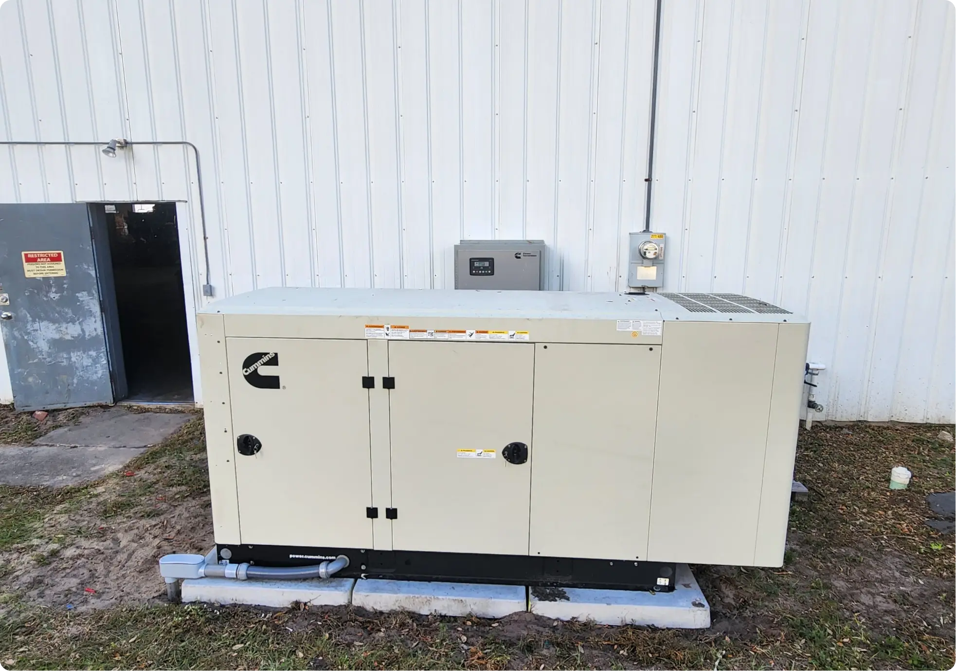 Cummins standby generator installed beside metal facility building