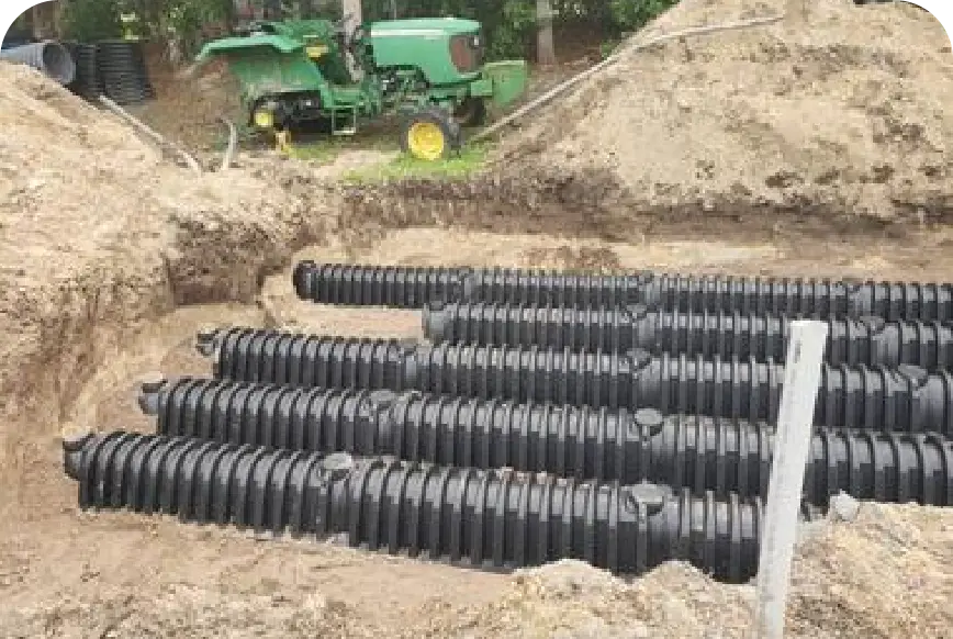 Leach-field chambers in trench with John Deere tractor behind