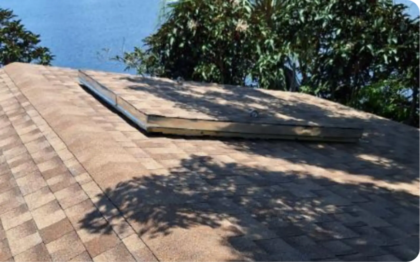 East Pointe Country Club roof shingles with new wood-framed curb beside lake