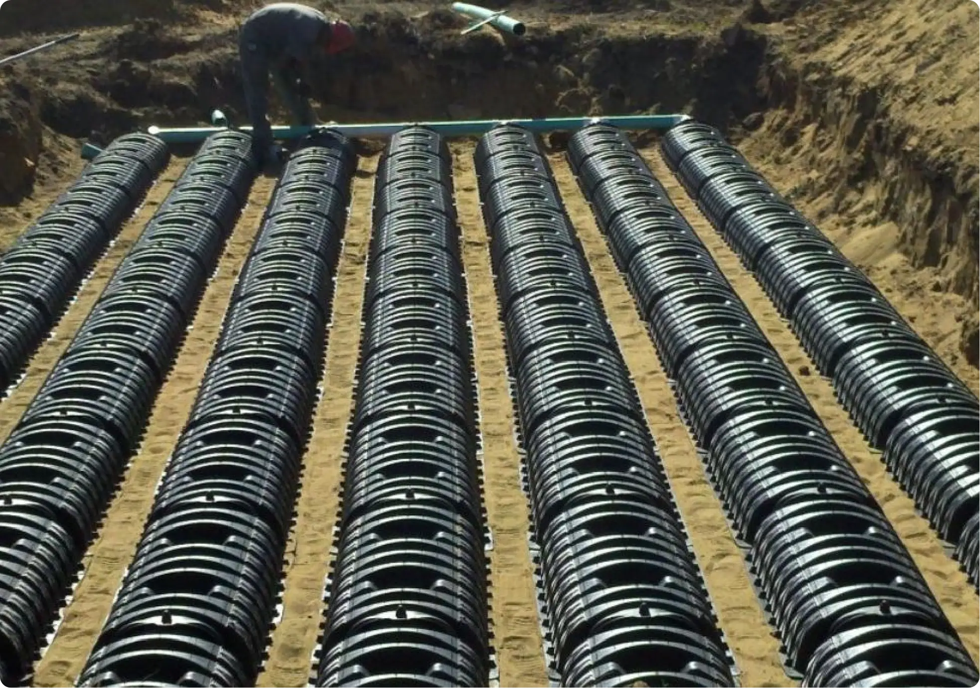Rows of black leach-field chambers installed in sand trenches