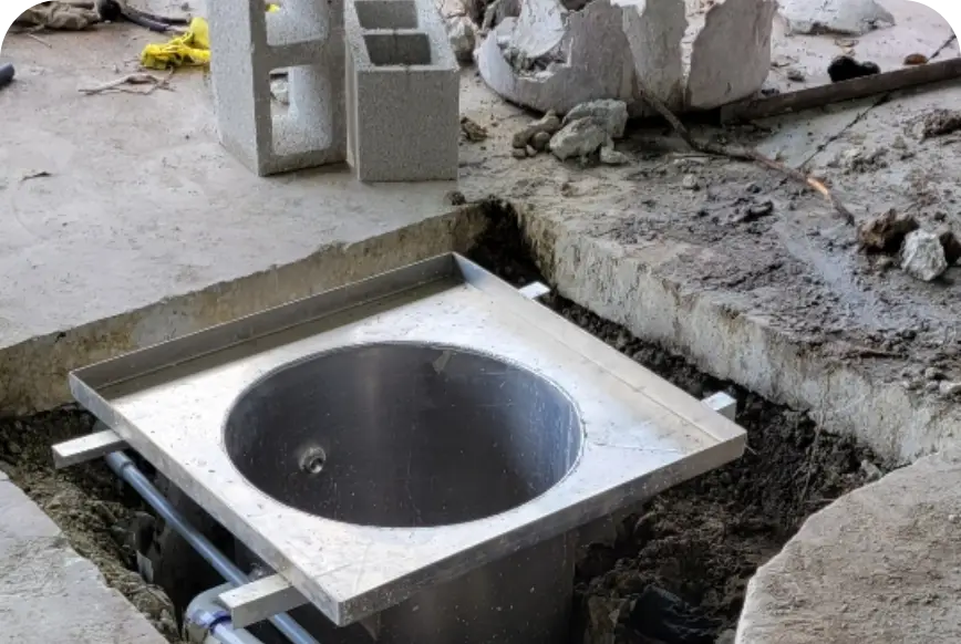 Stainless steel wash rack sump basin set in fresh concrete during installation