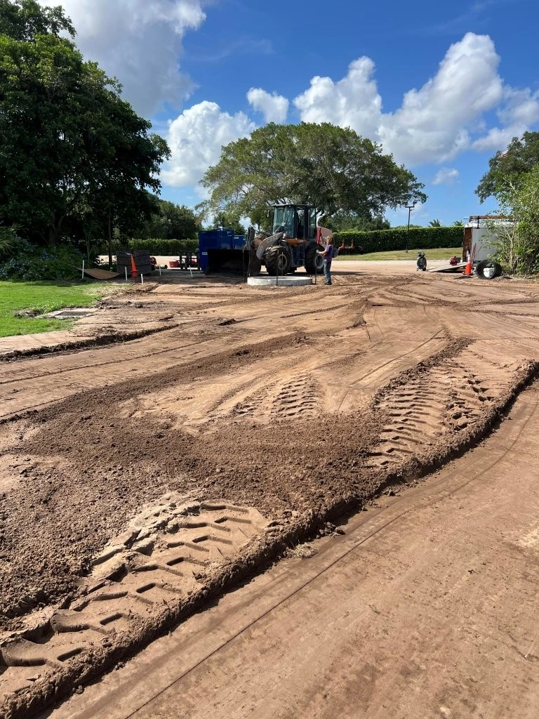 Tractor grading graded soil pad at golf course pump house site