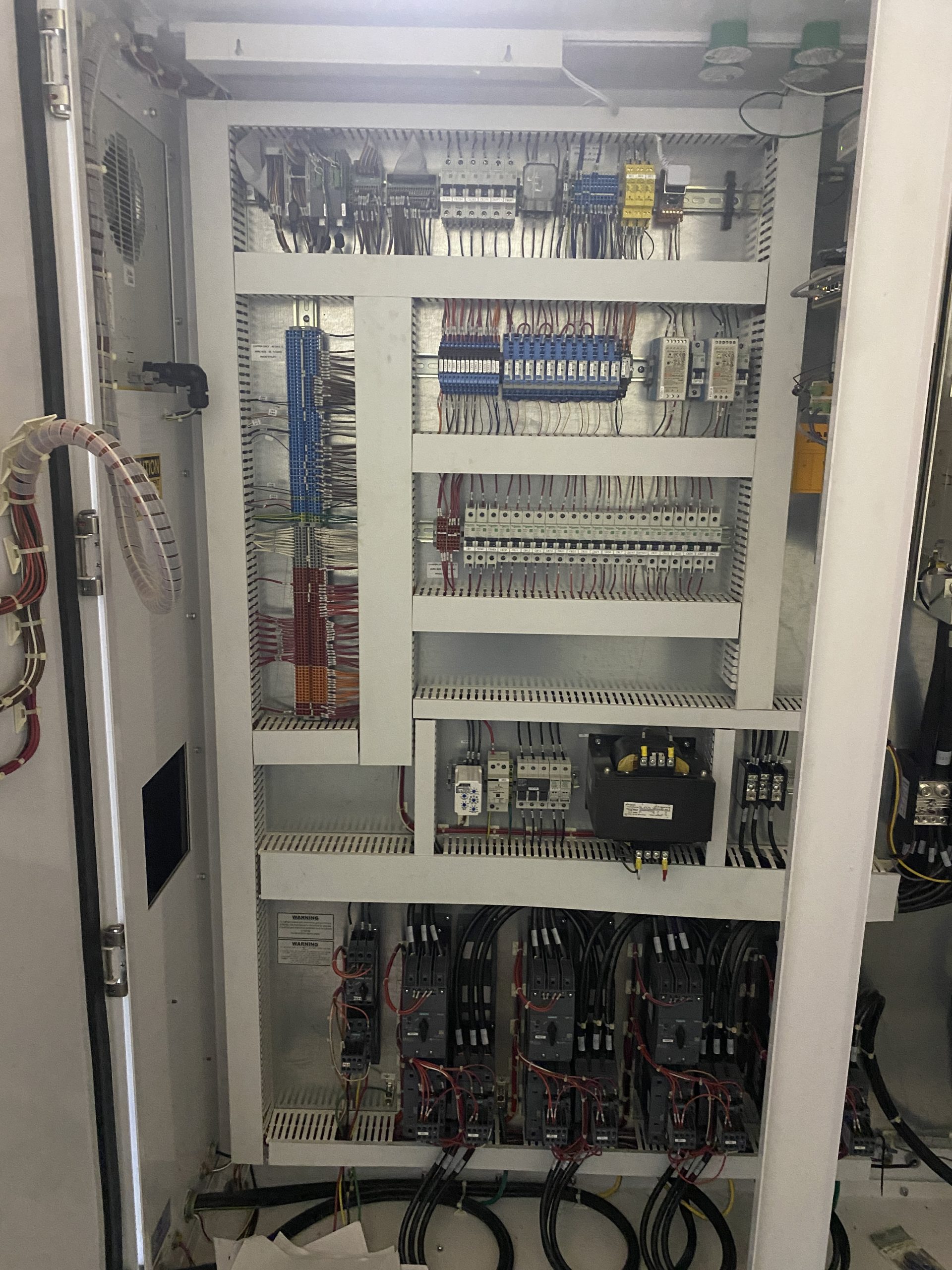 Open control panel with breakers, relays, and color-coded wiring