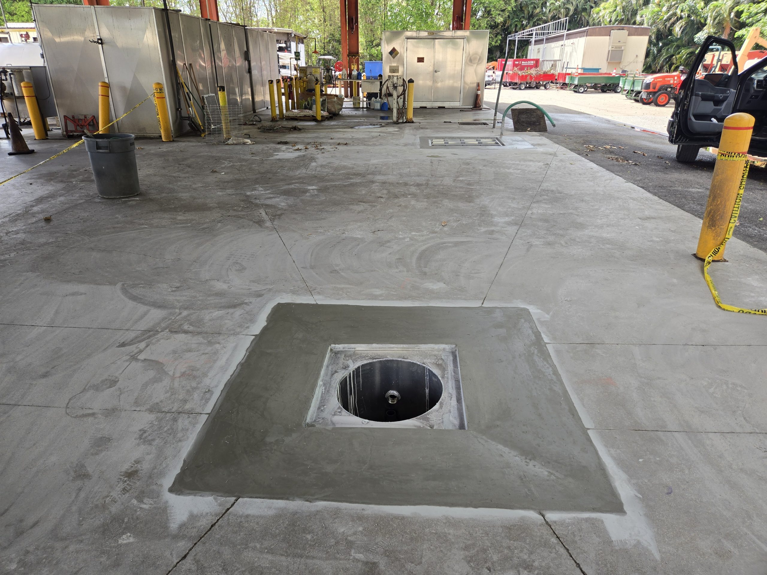 Restored concrete fuel-island pad with circular containment sump