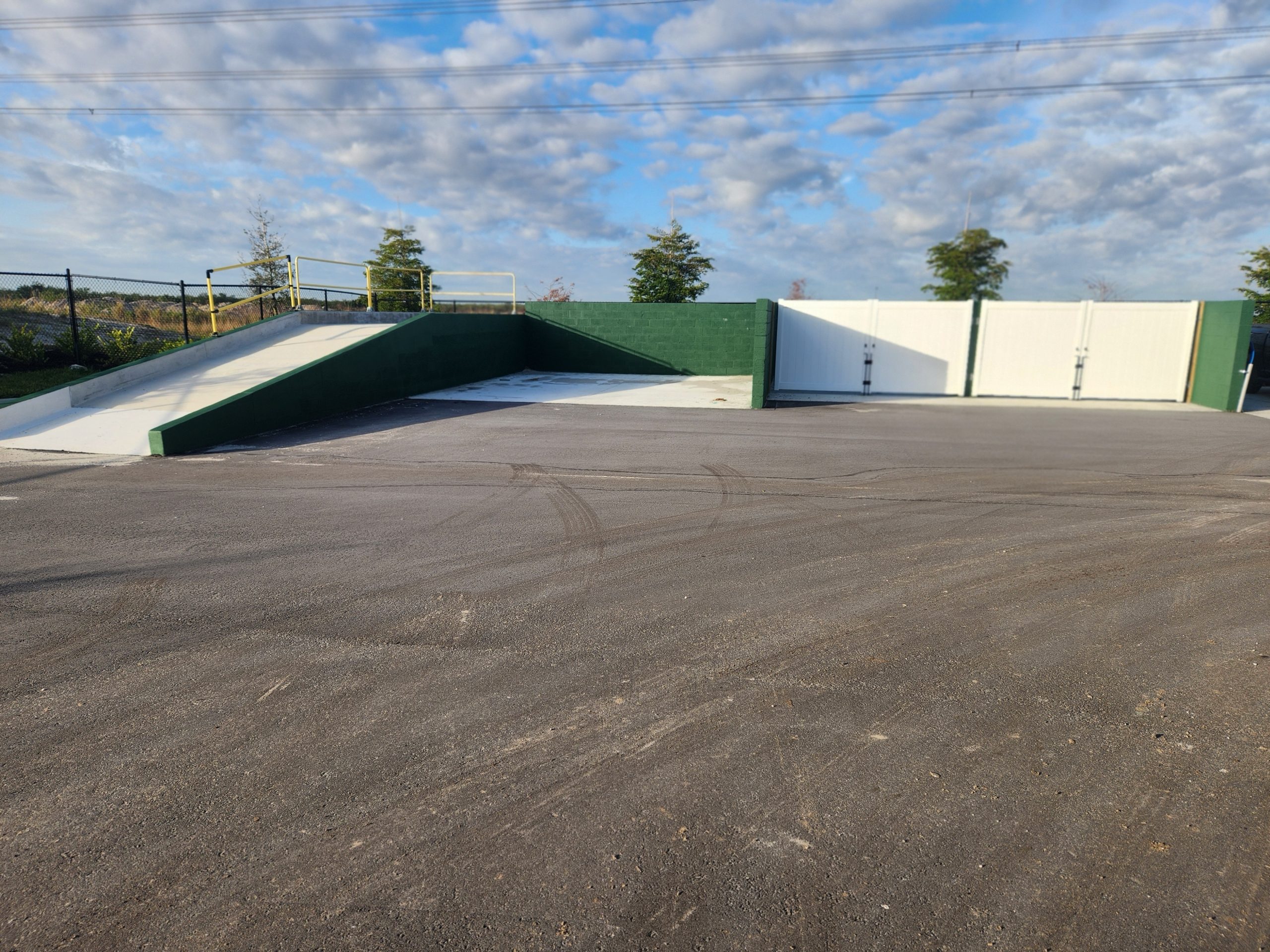Poured concrete wash pad with green retaining walls and ramp