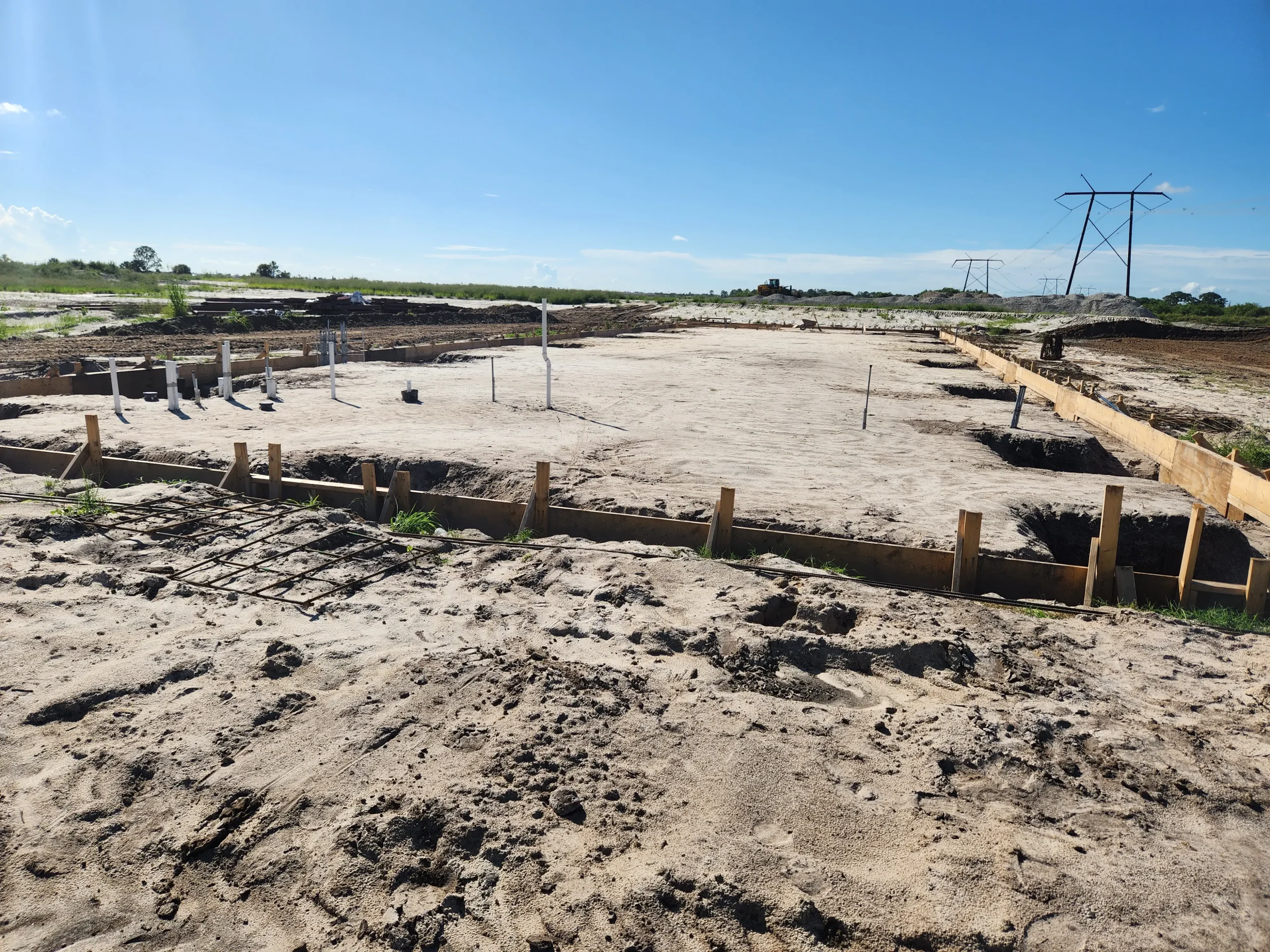 Formed footings on sand pad for new building foundation