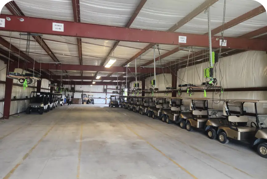 Golf carts parked in rows inside steel storage building