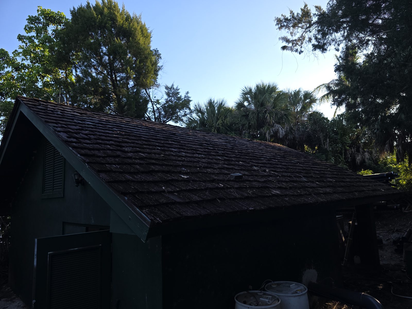 The Old Marsh pump house before reroofing, with an aged and weathered wood shake roof over green board-and-batten walls