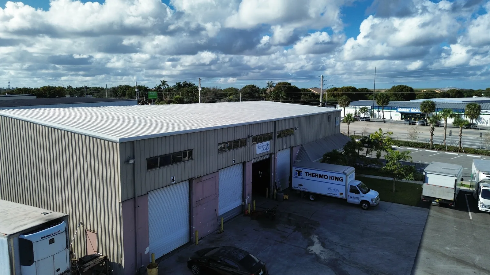 The Thermo King building before renovation, showing the original worn metal siding and aging roof on the existing footprint.