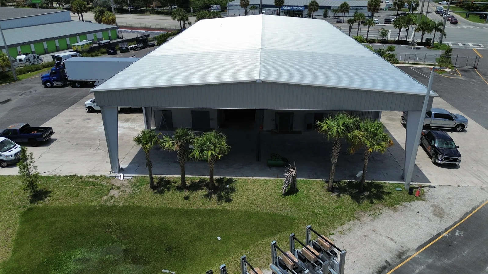 The finished covered wash bay added to the Thermo King facility, a hipped metal roof on columns providing a sheltered area for washing semi trucks.