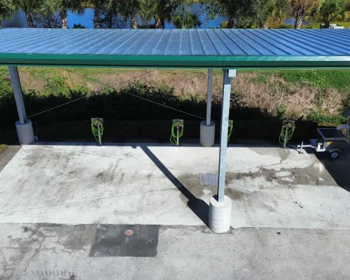Covered wash pad with green steel roof and wash stations, overlooking the golf course and lake