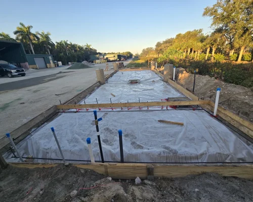 Wash pad formwork with vapor barrier and a centered floor drain ahead of the concrete pour