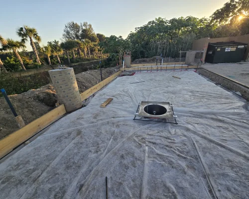 Prepared wash pad base with vapor barrier and an installed sump ready for the concrete pour