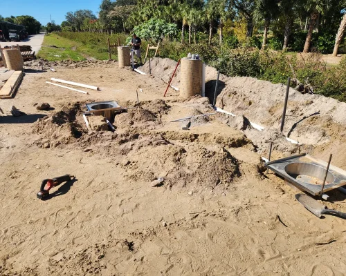 Two stainless steel sump basins being set into the prepared ground along the wash pad footprint