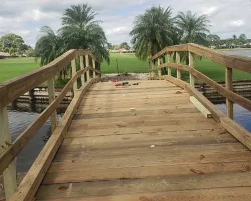 East Point new wood footbridge with railings across golf course pond