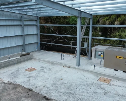 Construction view of the Naples Heritage steel frame with the poured concrete slab, relocated sumps, and stainless wash and mix station installed.