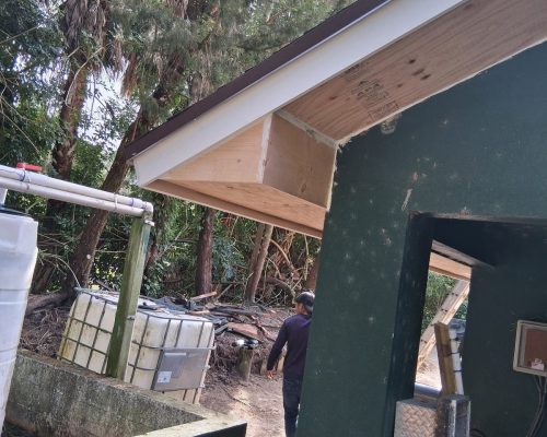 Renovated Old Marsh pump house showing the new soffit and fascia at the eave and the new diamond-plate access hatch on the building