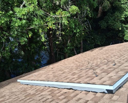 Detail of the new shingle roof on the Old Marsh pump house, with clean shingle courses meeting a crisp new white drip edge along the roof valley