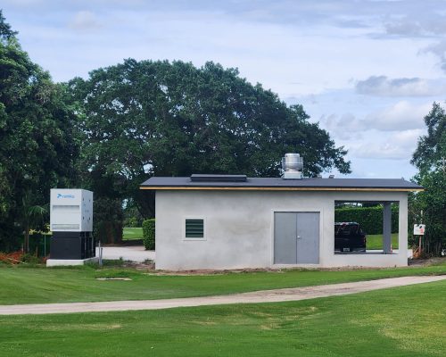 The finished Pine Tree Golf Club irrigation pumphouse with its enclosed pump room, covered equipment bay, and standby generator, set beside the course
