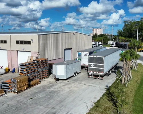 The Thermo King facility before the extension, with weathered siding, the original loading area, and trucks parked along the building.