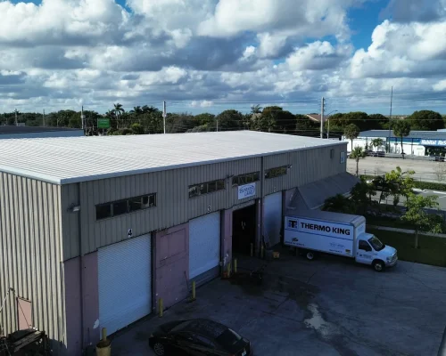 The Thermo King building before renovation, showing the original worn metal siding and aging roof on the existing footprint.