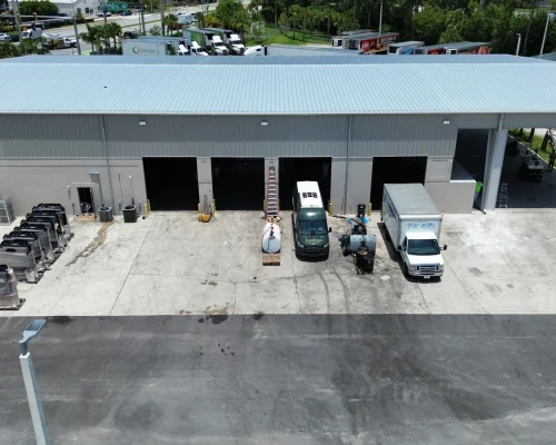 Interior drive-through of the new Thermo King wash bay with service trucks parked alongside a row of condensing units under the covered extension.